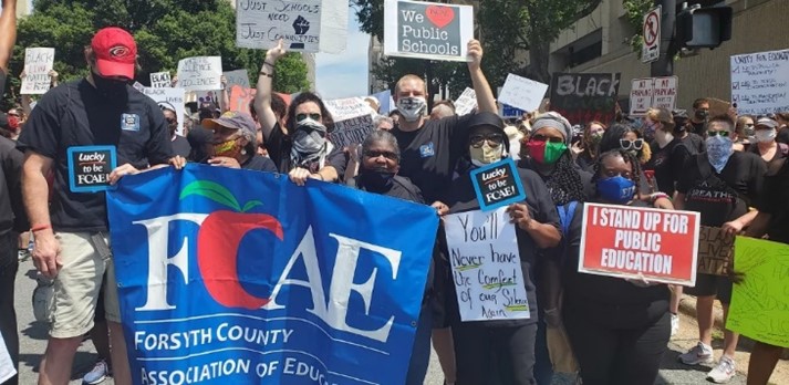 FCAE members outside holding signs and an FCAE banner at an educators rally.